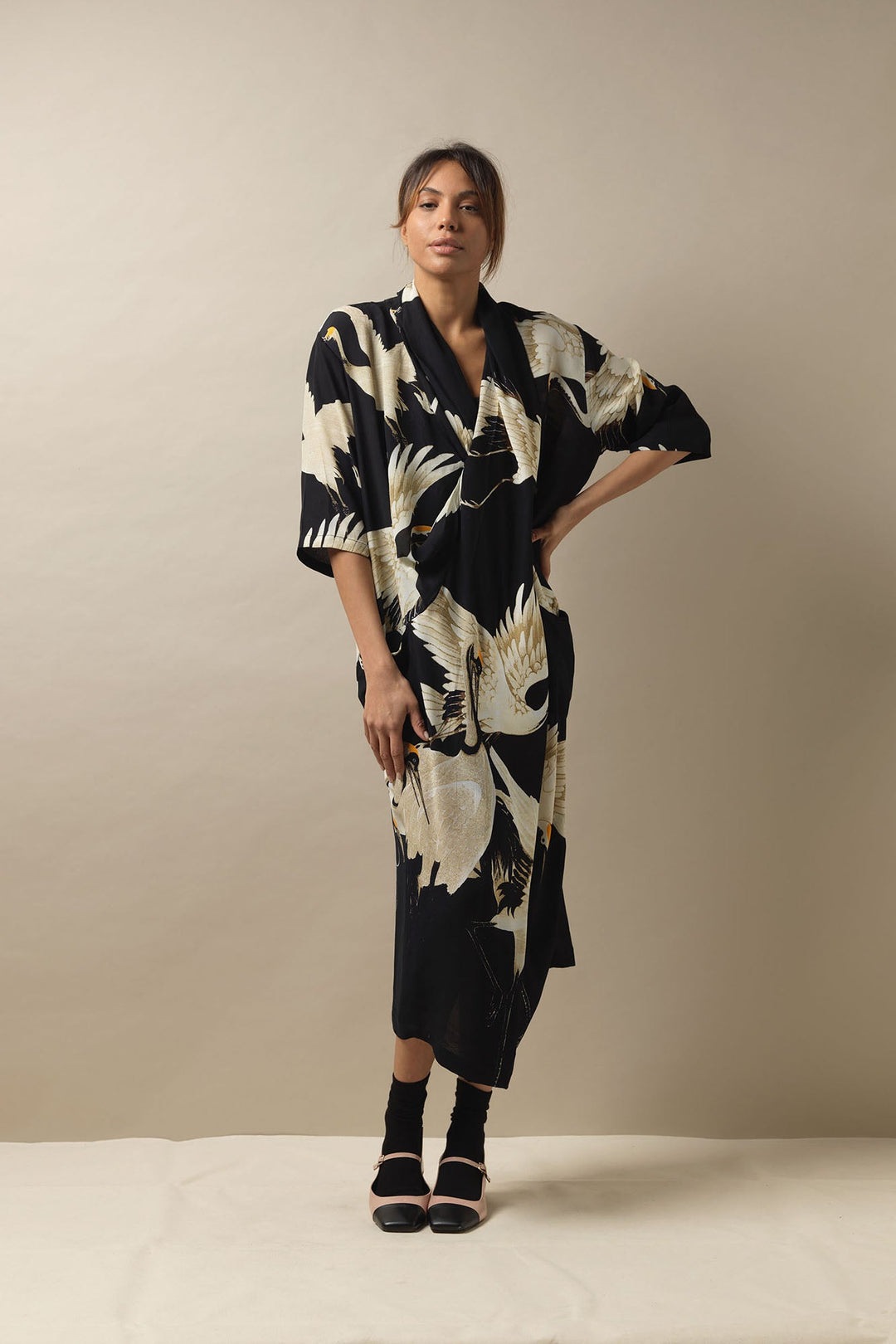 One Hundred Stars Stork Crane Black and White Dress. This cowl neck, V line dress features a pin tuck front, pockets and can be styled with your own additional belt to create a silhouette look. Midi length black dress, versatile day to night outfit. Mid length wedding outfit.