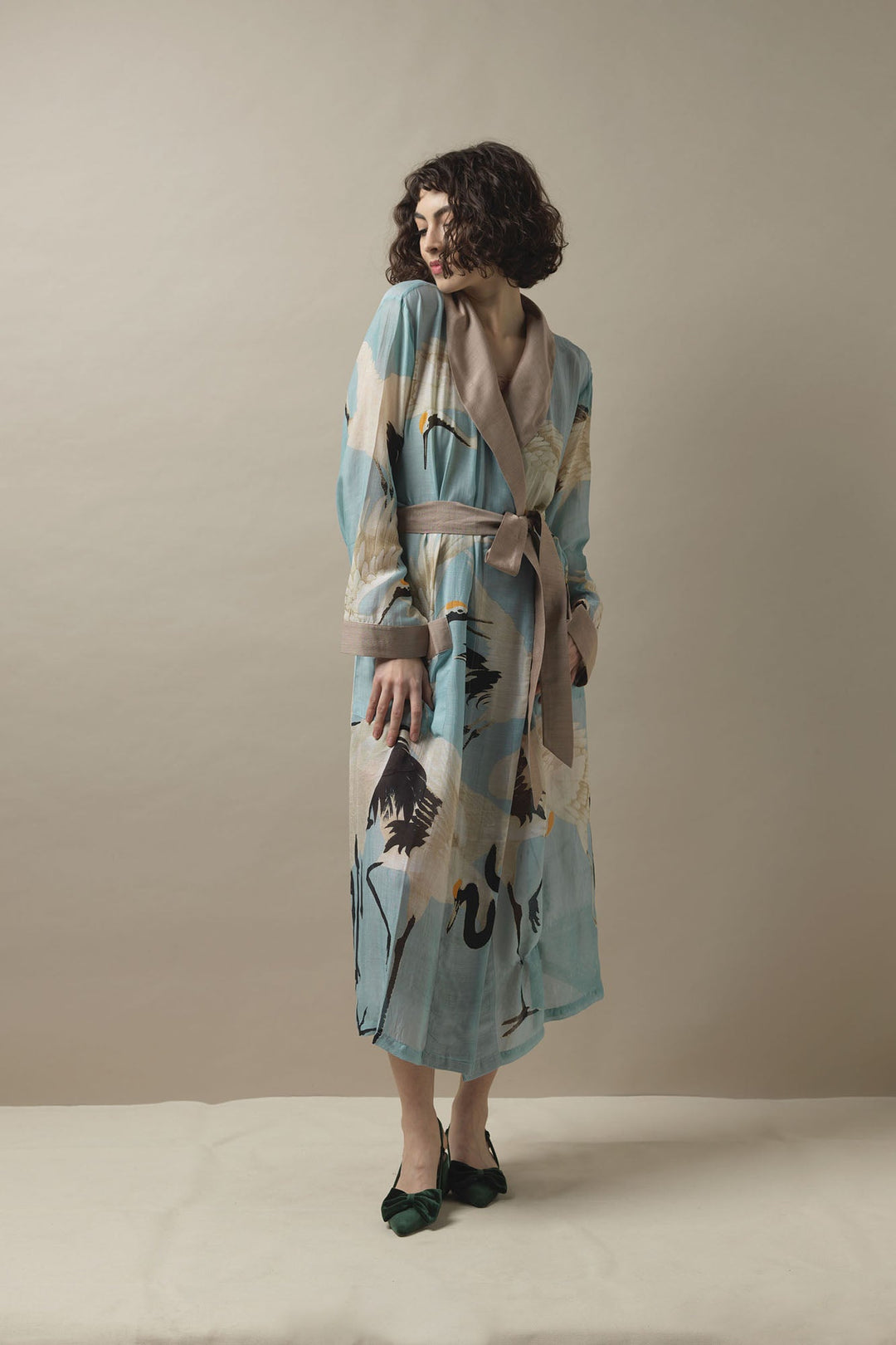 This lightweight design falls to an elegant long length and features a fold over collar, complete with self-tie waist belt and front patch pockets.